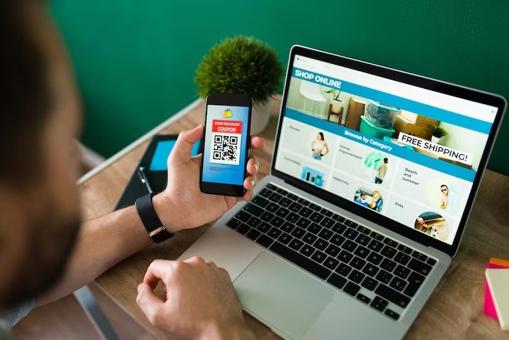 imgi_4_young-man-using-discount-coupon-his-smartphone-some-online-shopping-laptop_662251-2177
